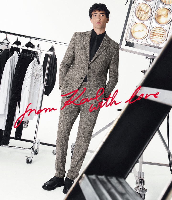 Man in a gray suit standing in a studio with text 'From Karl with love' on a white background.