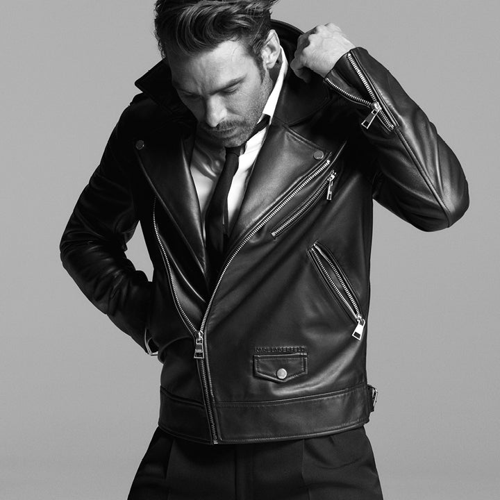Man wearing a black leather jacket against a gray background