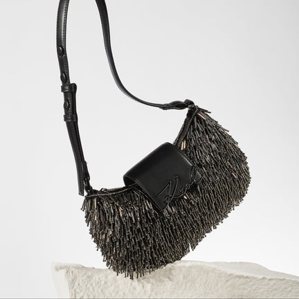 Black fringe handbag on a light gray background