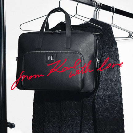 Black leather briefcase with 'from Karl with love' text on a hanger.