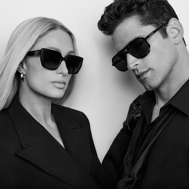 Black and white photo of two people wearing sunglasses against a plain background